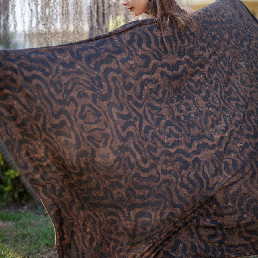 A woman wearing the Artist Collab: Daniel Dugan x One Golden Thread Nature Wrap in Egyptian Tan color